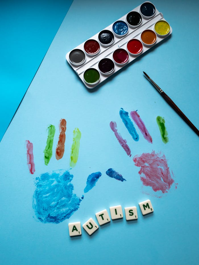 Vibrant concept art showcasing autism awareness with handprints and scrabble tiles.